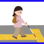白杖を使って点字ブロックの上を歩く女性