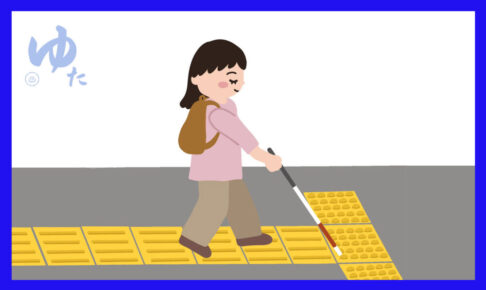 白杖を使って点字ブロックの上を歩く女性