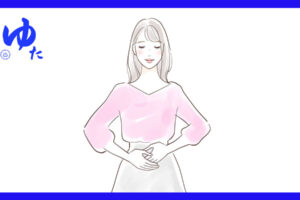 おなかに両手を当てた女性が立っている