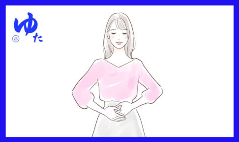 おなかに両手を当てた女性が立っている