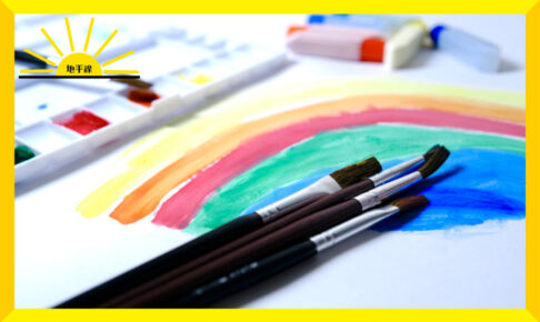 虹の絵と絵筆や絵の具、パレットの写真