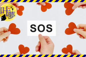 SOSと書かれた札を持つ手の周りに赤いハートの紙を持った手がある