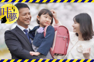 桜の木に囲まれて笑い合う夫婦と子ども
