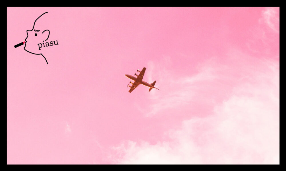 ピンク色の空の中を飛ぶ飛行機