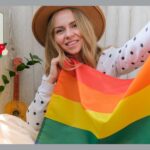 LGBTQの旗を持つ、トランスジェンダーの男性