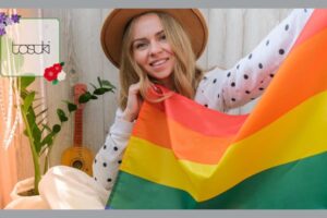 LGBTQの旗を持つ、トランスジェンダーの男性