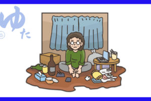 散らかった部屋で一人座っている男性