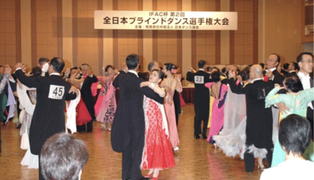 ブラインドダンスの大会で社交ダンスの衣装を着て踊る男女
