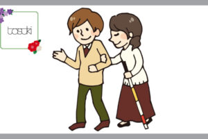 視覚障害者の女性を支える男性