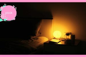 電気を消した寝室の、ベットサイドにあるテーブルに置かれた、丸い形の照明と、ラップトップパソコン