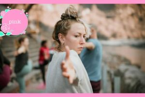 数人でヨガのポーズをしている中、髪の毛をお団子結びにしている女性