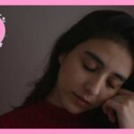 目を閉じて、握りしめた左手に頬をあずけている女性
