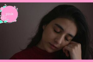 目を閉じて、握りしめた左手に頬をあずけている女性