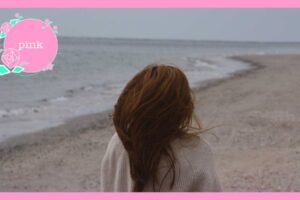 誰もいない海辺に、一人佇んでいる女性