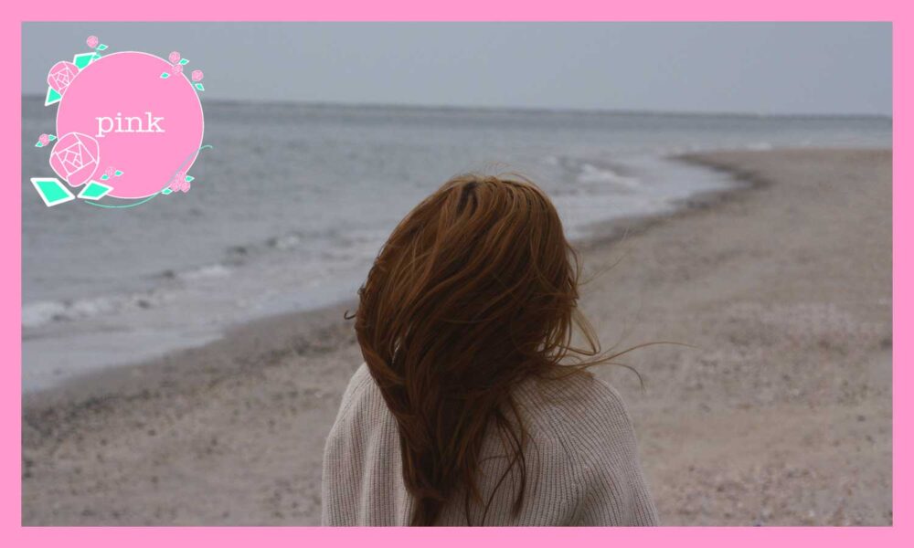 誰もいない海辺に、一人佇んでいる女性