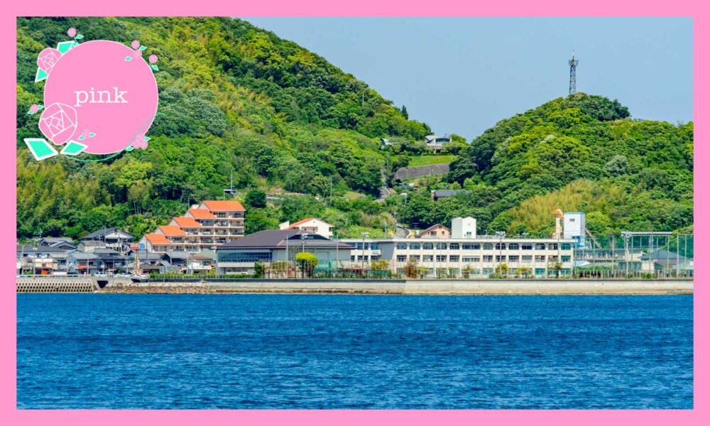 後ろが山で、前が海の間にある高校の校舎