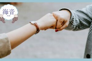黒と白の長袖のシャツを着た人が茶色のコートの女性と手をつないでいる