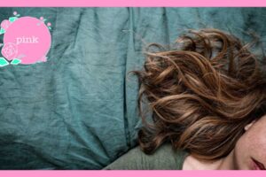 シーツの上に、目を閉じて横たわる女性
