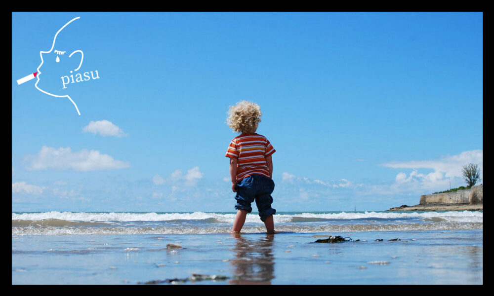 幼い子どもが海辺に立っている様子