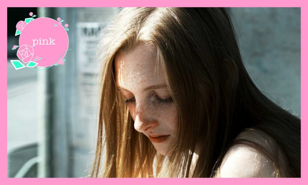 目を閉じて下を向いている髪の長い女性