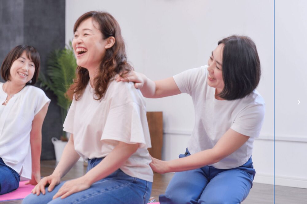 施術を受ける女性と笑顔の女性2人