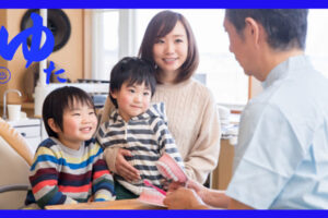 歯医者の先生に歯の治療について説明を受ける二人の男の子とそのお母さん