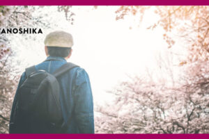 桜を見上げる帽子をかぶった男性