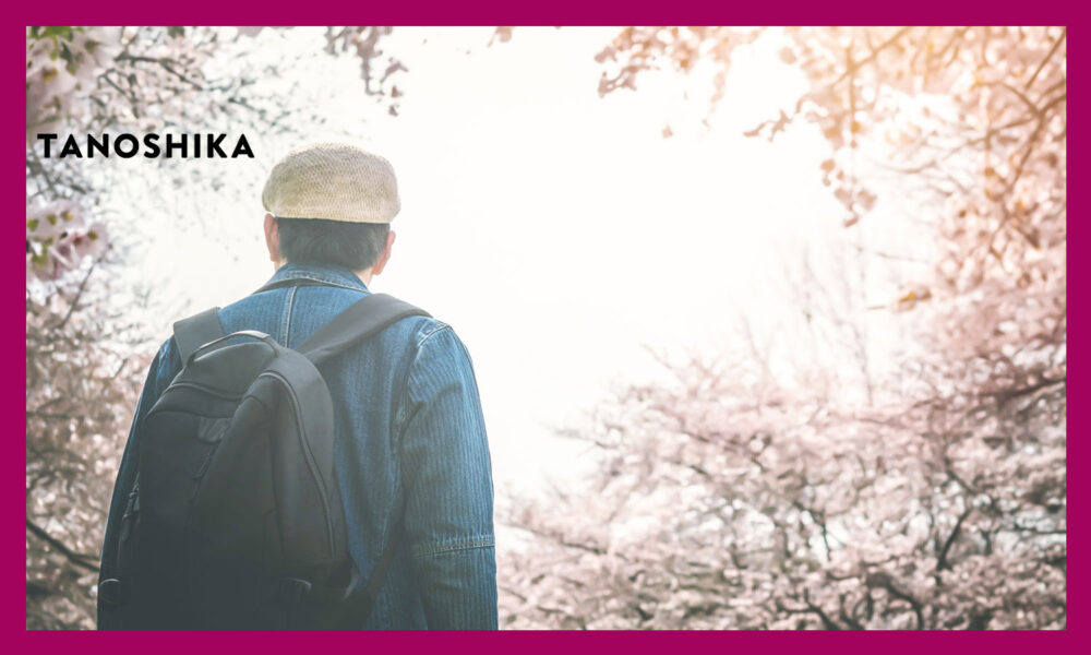 桜を見上げる帽子をかぶった男性