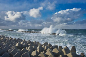青空と雲と海岸に並べられたテトラポット