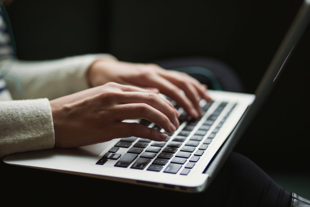 パソコンのキーボードを打っている人の手元