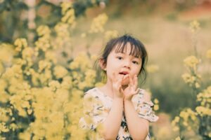 花畑の中でこちらを見つめる少女