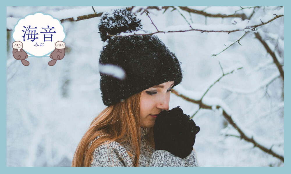 帽子をかぶって雪の中に立つ女性