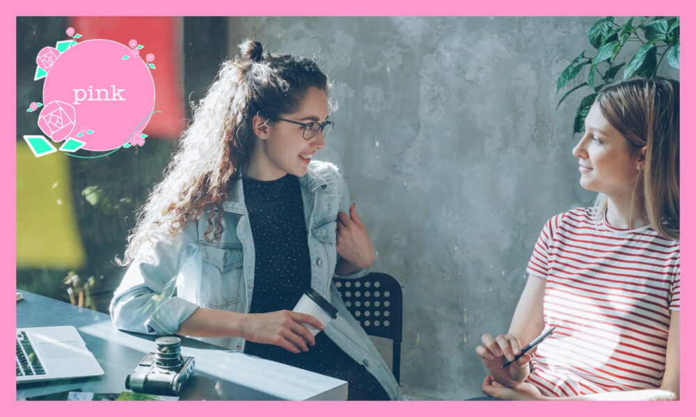 明るいオフィス内で、話をしている2人の女性