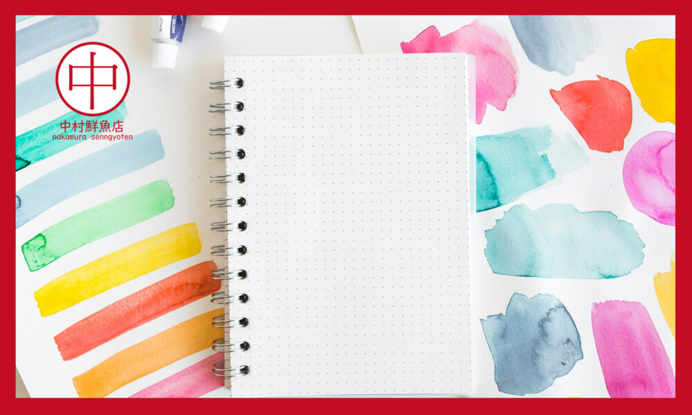 カラフルな紙の上にノートとペン