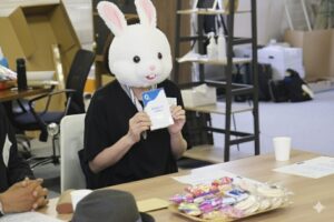 ウサギの被り物を被った女性がトークカードを周りの人に見せている
