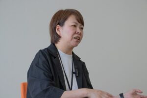手振りをしながら話す女性（林さん）
