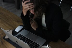 パソコンを前に頭を抱える悩んでいる女性