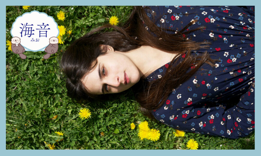 たんぽぽの隣に寝ている女性