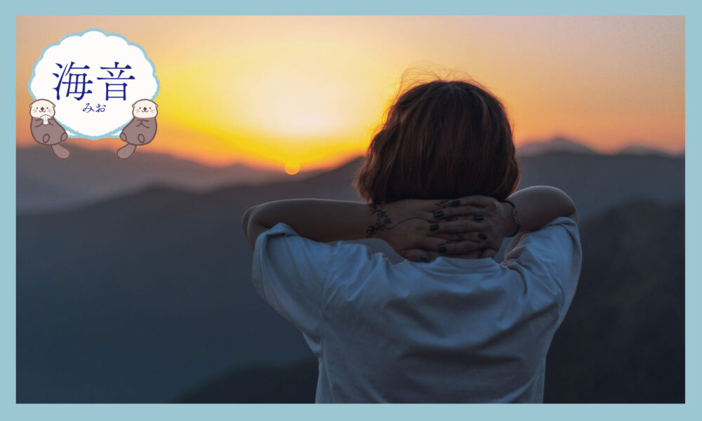 立って夕日を見る女性