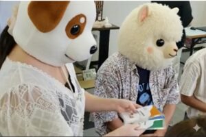 犬の着ぐるみを被っている人が周りの人にトークカードの説明をしている