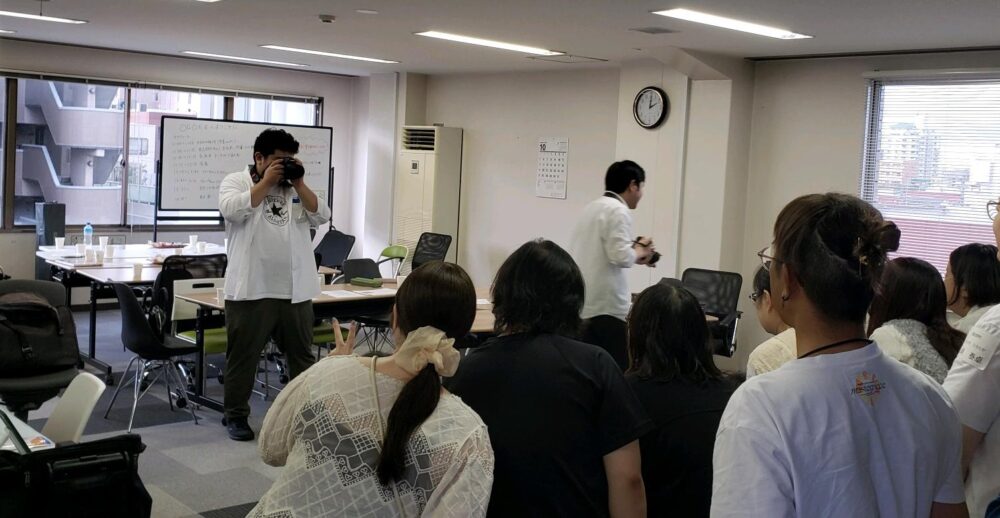 集合写真撮影の様子を撮られる側の後ろから見ている