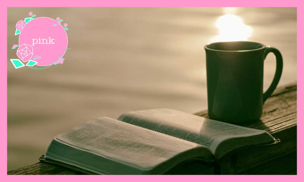 水面に光りが差し、そばに置かれた緑色のカップと、開いたままの１冊の本