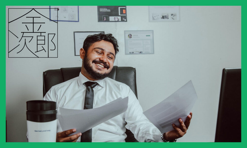 書類を見比べながら笑っているビジネスマン