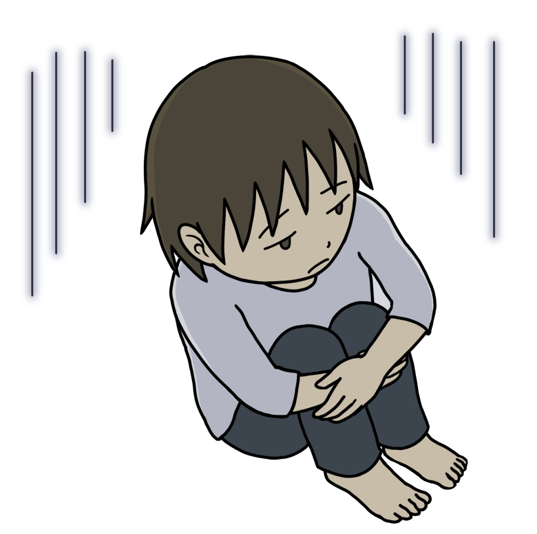 膝を抱えて落ち込んでいる人