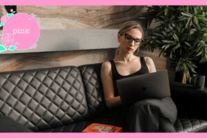 ソファに座り、ノートパソコンを見ている眼鏡をかけた女性