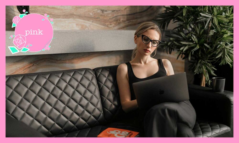 ソファに座り、ノートパソコンを見ている眼鏡をかけた女性