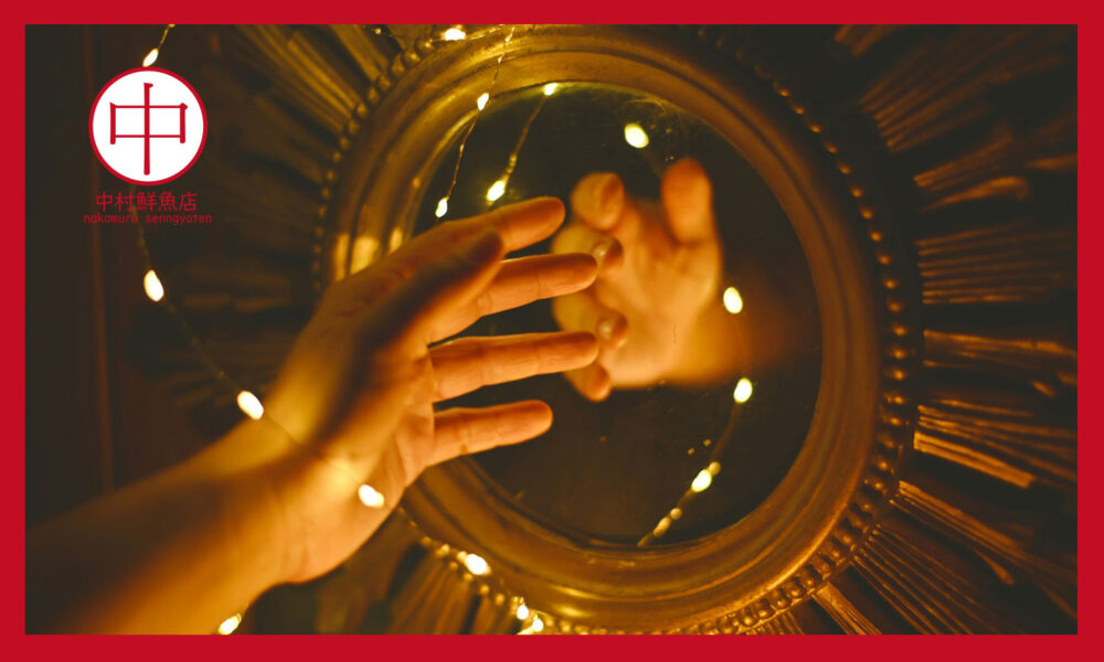 鏡に映る右手と小さな光