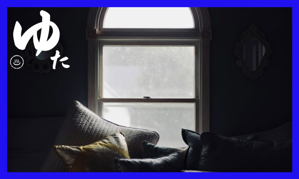 暗闇の中で明かりを照らす窓とソファー