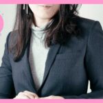 ハイネックにスーツのジャケットを着ている女性