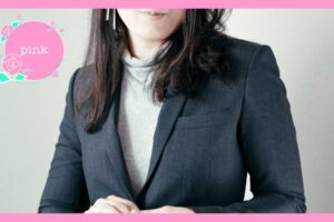 ハイネックにスーツのジャケットを着ている女性